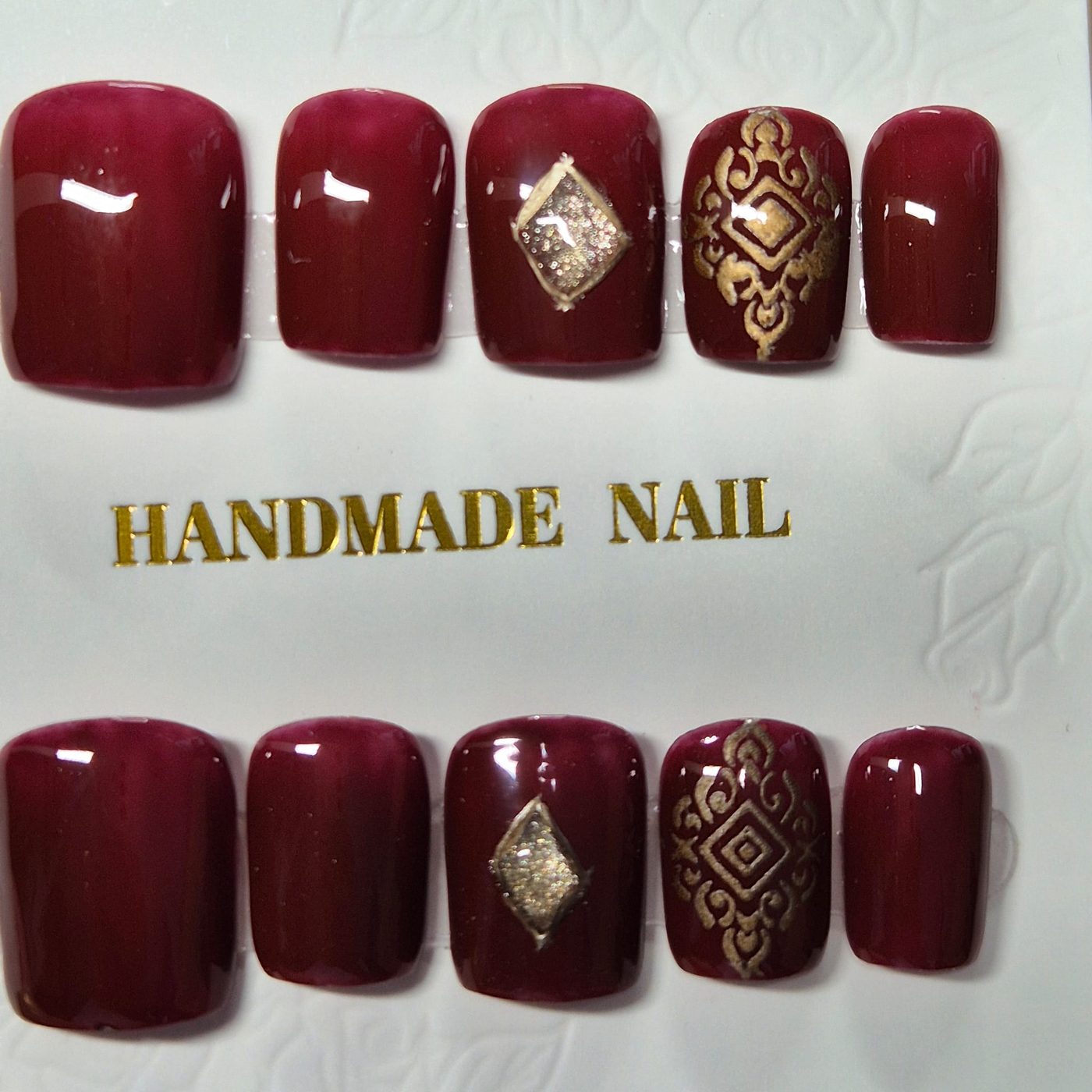 Maroon press-on set with gold mehndi motifs